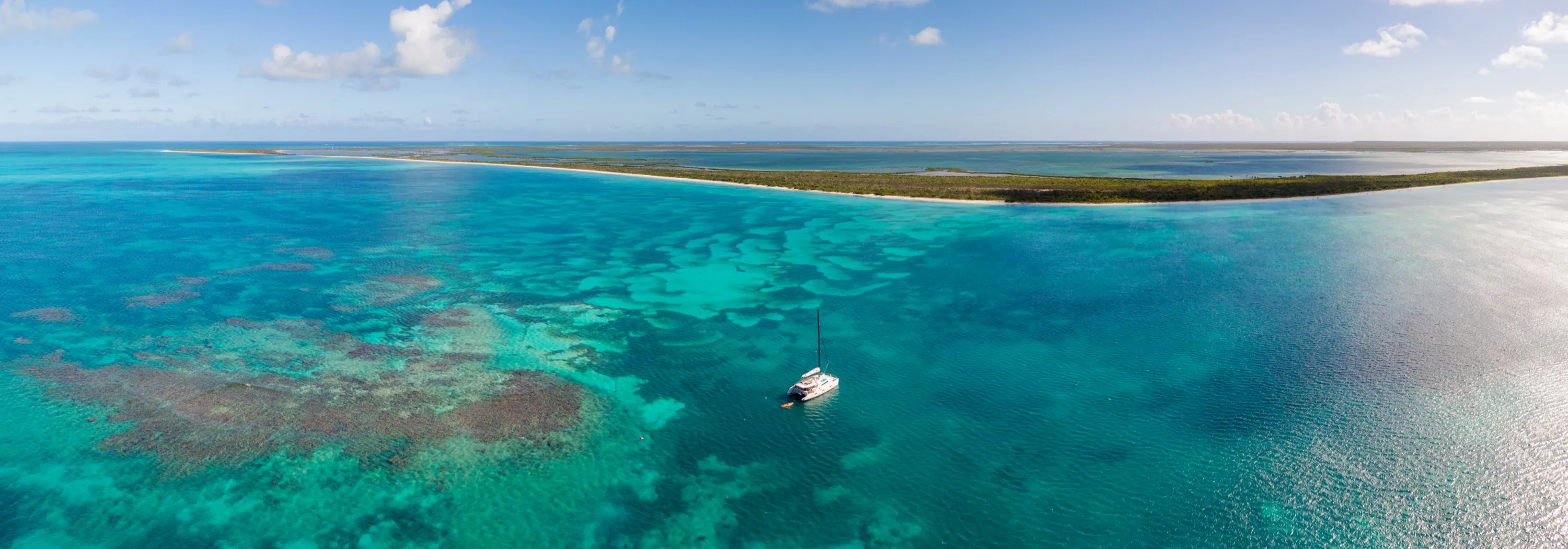 Un catamaran seul au mouillage au milieu du récif, au large de Barbuda